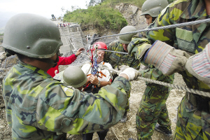13日，臺灣高雄縣六龜鄉(xiāng)新開村有20多戶遭泥石流淹沒。圖為軍人正陸續(xù)將生還者救出。