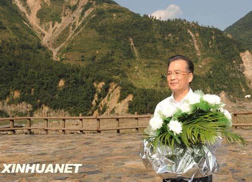 溫家寶總理十分關(guān)注災(zāi)后重建進(jìn)展情況。在國慶節(jié)和中秋佳節(jié)即將來臨之際，他第8次踏上了一直牽掛的這塊土地。在9月24日至26日的三天時(shí)間里，他奔波穿行于地震重災(zāi)區(qū)的城鄉(xiāng)間，為節(jié)省時(shí)間，吃飯盡量安排在火車上；連續(xù)兩個晚上主持召開會議，就災(zāi)后恢復(fù)重建的一系列重大問題進(jìn)行研究部署。這是9月24日，溫家寶在青川縣紅光鄉(xiāng)東河口村地震遺址祭奠臺獻(xiàn)花。新華社記者黃敬文攝