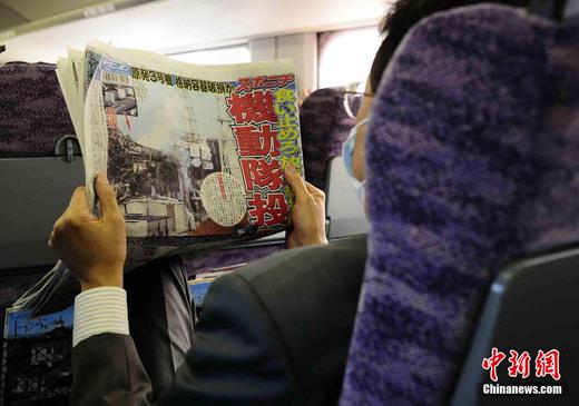 3月17日下午，在一列前往東京的新干線列車(chē)上，一名日本人在閱讀關(guān)于福島核電站三號(hào)機(jī)組最新?tīng)顩r的報(bào)道。中新社發(fā) 侯宇 攝