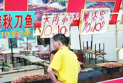 被查后，美食街上的'羊肉串'的'羊'字被涂抹了。
