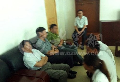 在壽光市人民醫院接待室，3名死者家屬向院方人員下跪，院方人員表情漠然。