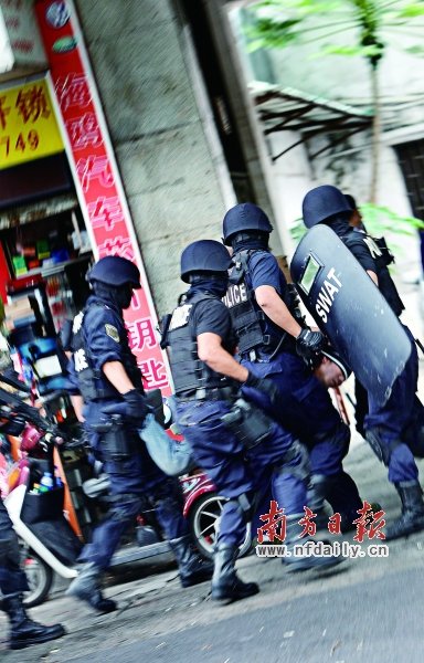 特警將嫌疑人（紅圈內）押上警車。