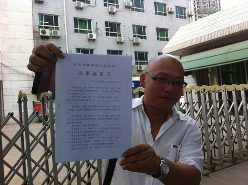 藥慶衛代理人馬延明在法院門口向記者展示裁定書（來源：王甲鑄攝）