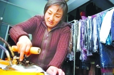 資料圖：鄒春蘭在自己洗衣店內工作。圖片來源 揚子晚報