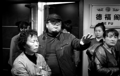 昨日，在河北香河天下第一城，相關負責人（左二）走出會議室與參加演出的老人們溝通。