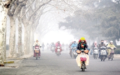 昨天上午，中原路，行人在霧霾中騎車出行，很多行人戴上了口罩。
