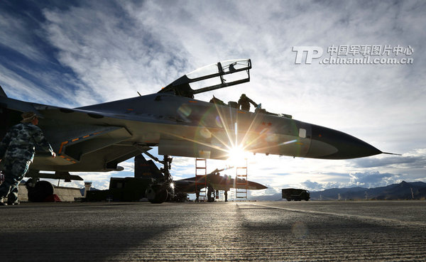 成都軍區空軍航空兵某師機務和場站官兵在西藏高原某機場緊張準備戰機。