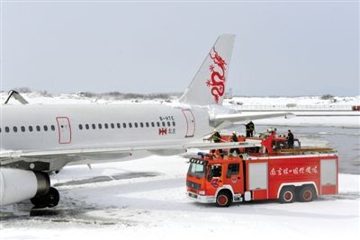 2月19日，南京祿口國際機場工作人員在清理飛機上的積雪。新華社發