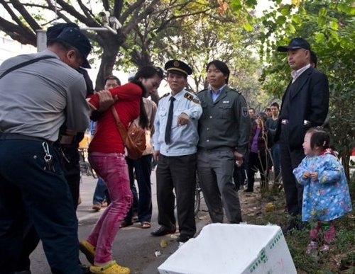城管與女小販發生沖突后，女小販被警方強行帶走，她的孩子在一旁放聲大哭。南都記者 黎湛均 攝