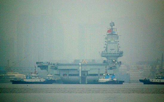 資料圖：大連港口大霧彌漫，中國首艘航母“遼寧艦”徐徐離開港口。