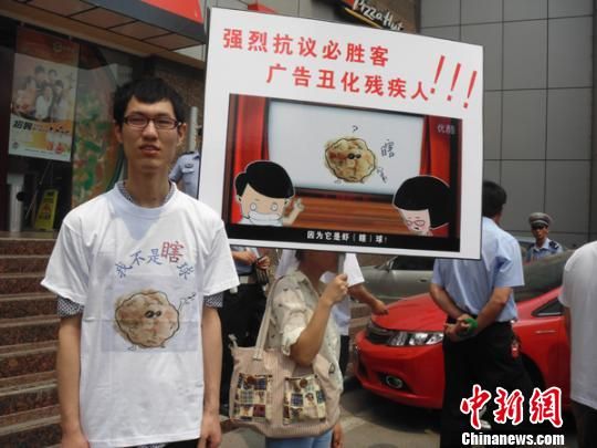 6月5日，視障人士在鄭州一必勝客門前舉牌抗議蝦球廣告歧視。 門杰丹 攝